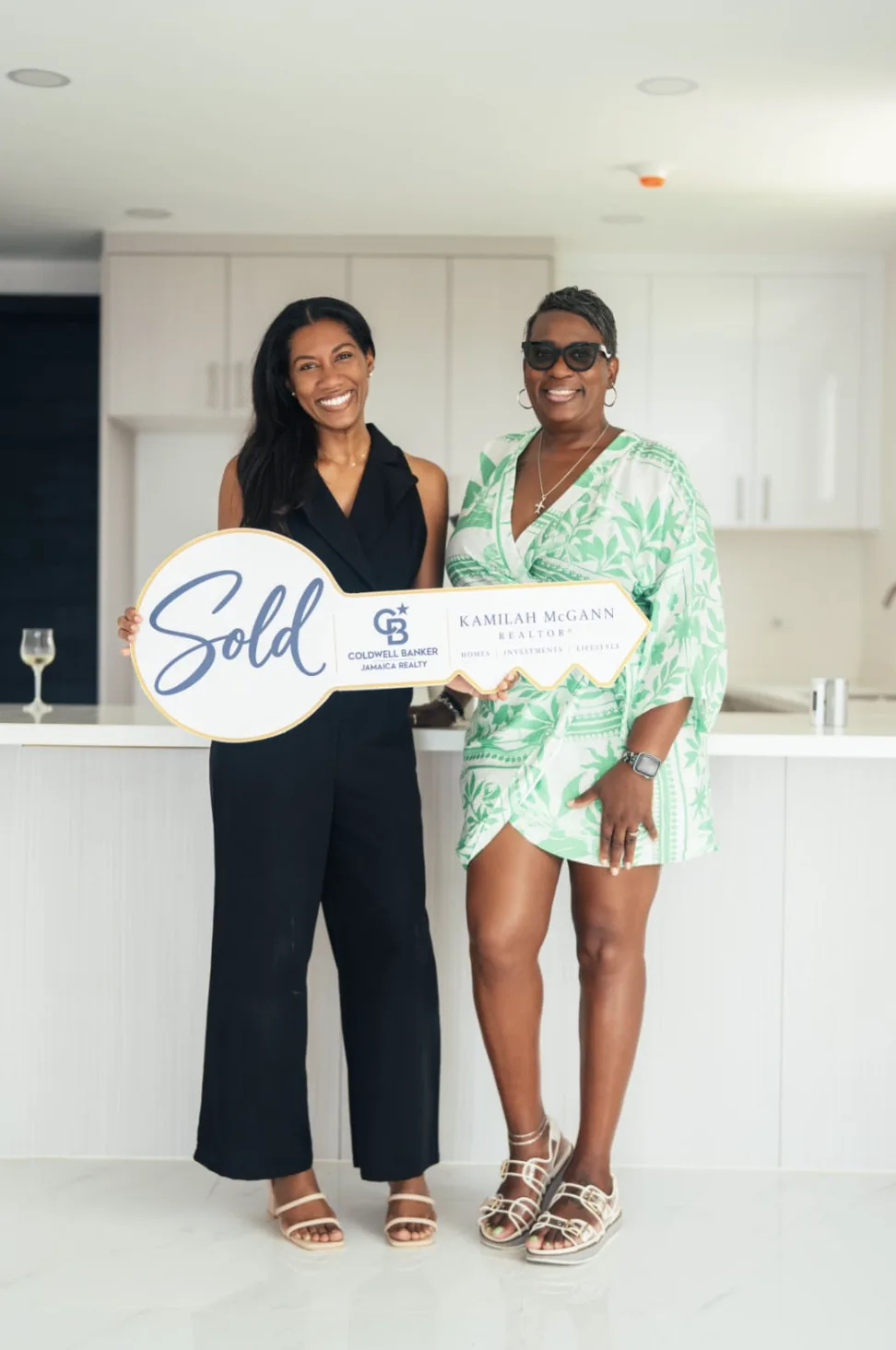 Kamilah with a client holding a Sold key after a closing