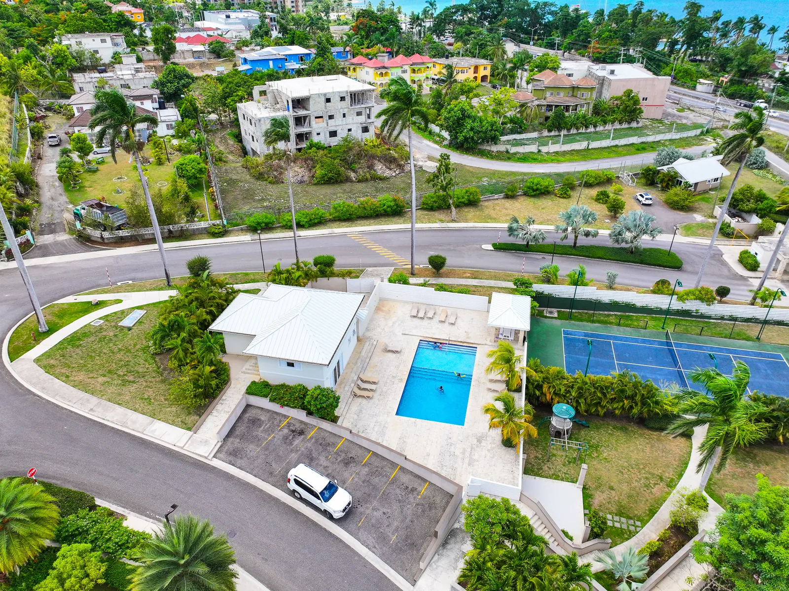 Clubhouse, pool and tennis court at the TARA Apartments community